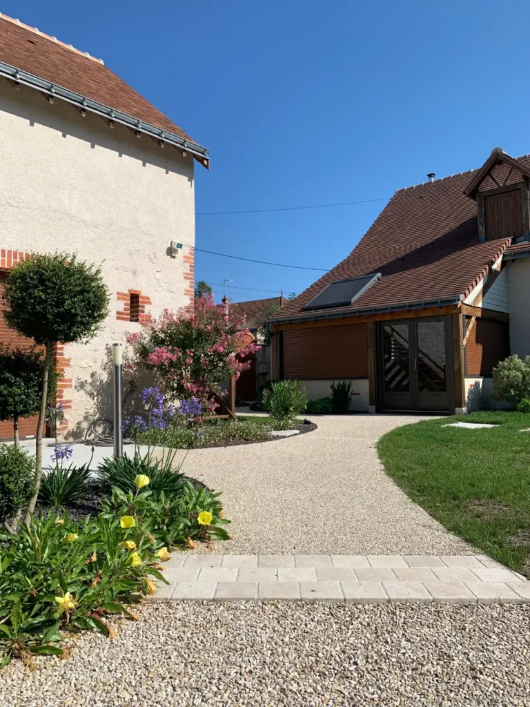 Maison avec jardin paysager et allée courbe