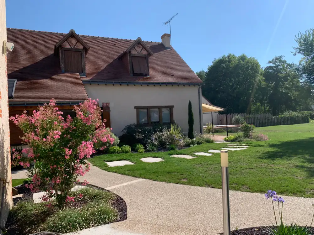 Maison avec jardin fleuri et pelouse ensoleillée