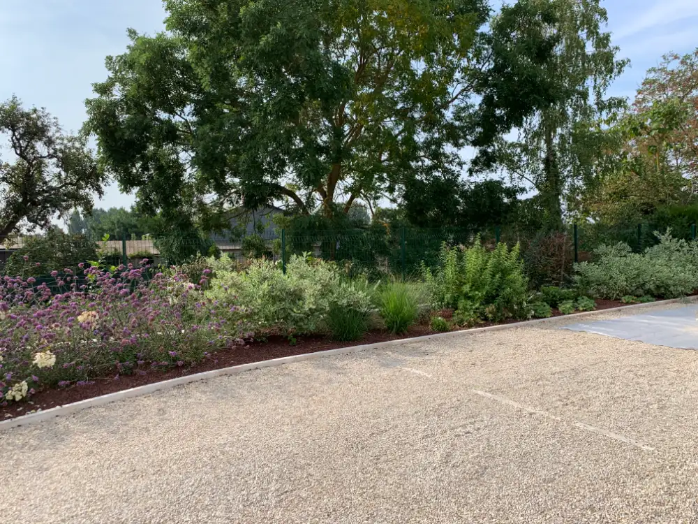 Jardin paysager avec massifs fleuris et allée gravillonnée