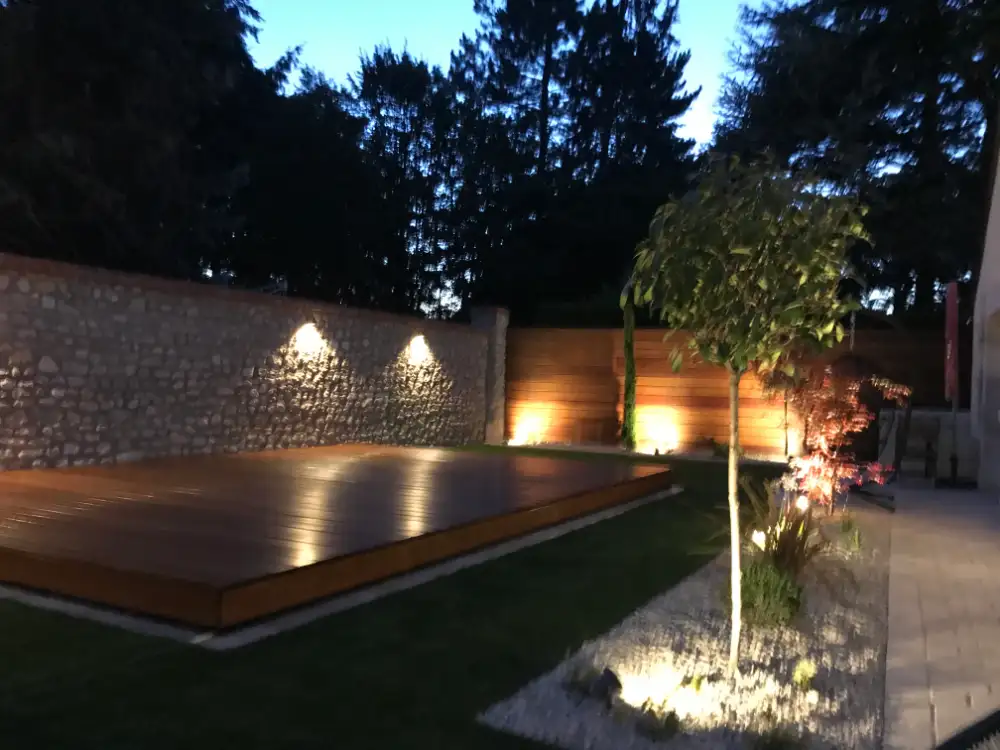 Terrasse en bois éclairée dans jardin moderne