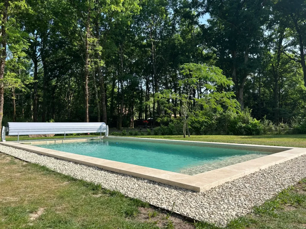 Piscine rectangulaire dans jardin boisé et verdoyant