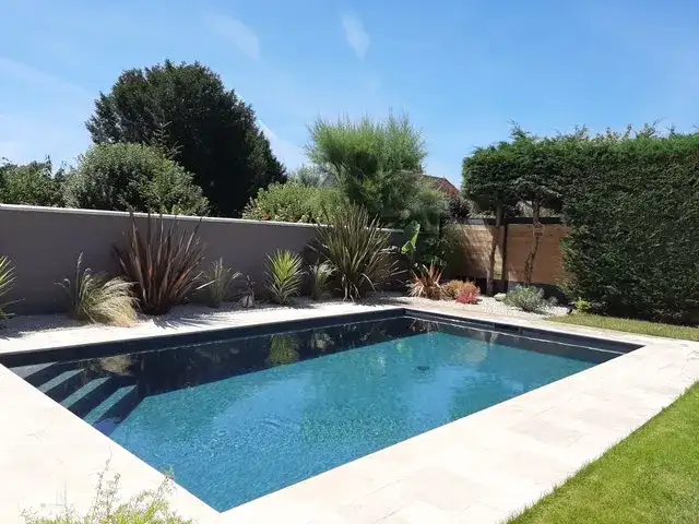 Piscine moderne dans jardin paysager ensoleillé