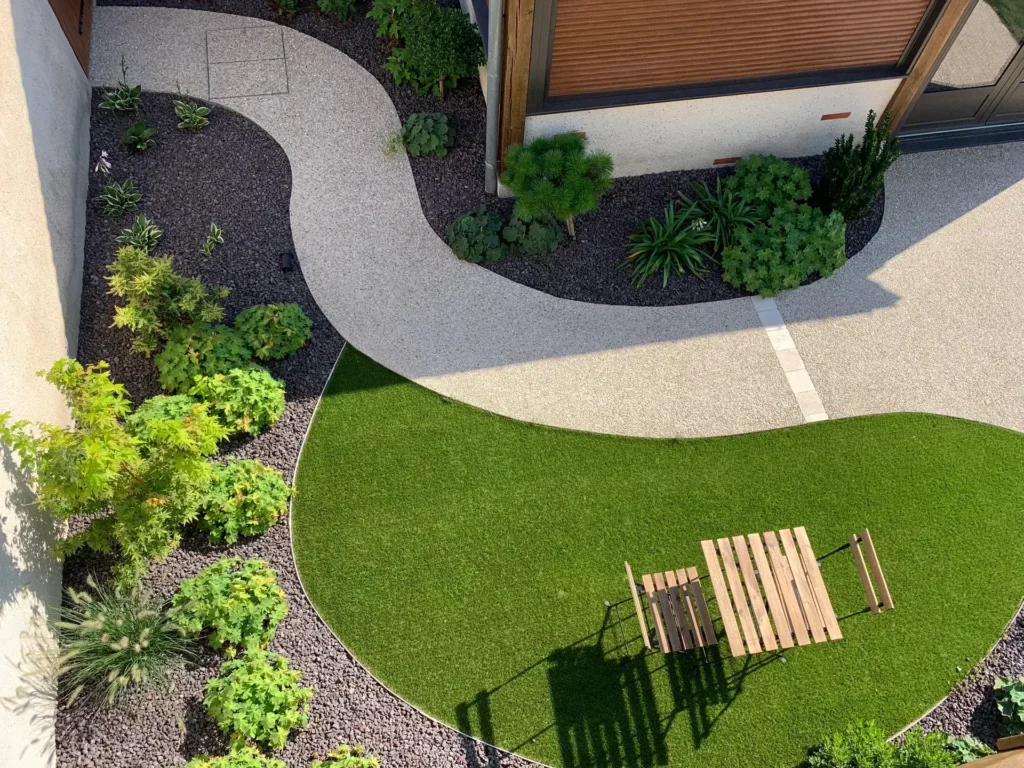 Jardin moderne avec allée courbe et pelouse verte