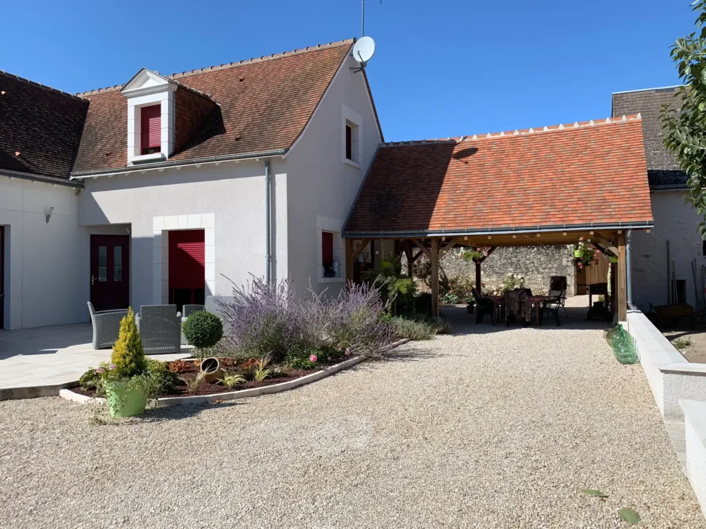 Maison avec volets rouges et cour aménagée
