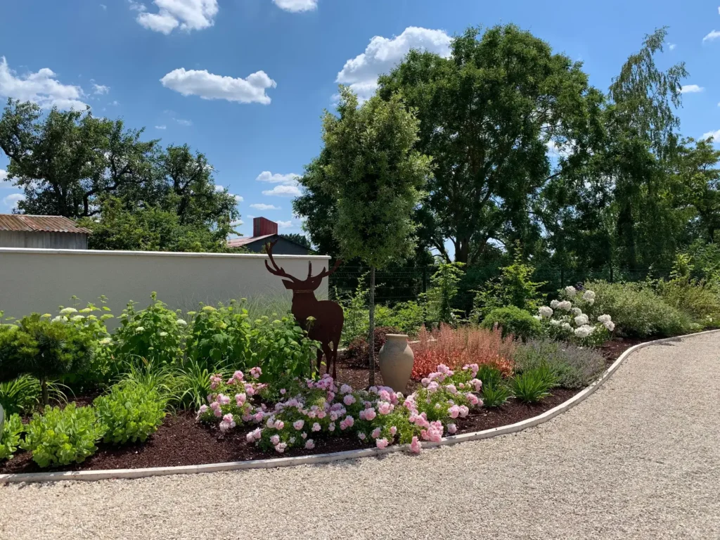 Jardin paysager avec sculpture de cerf et fleurs