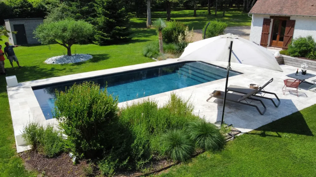 Piscine moderne dans jardin paysager avec transats