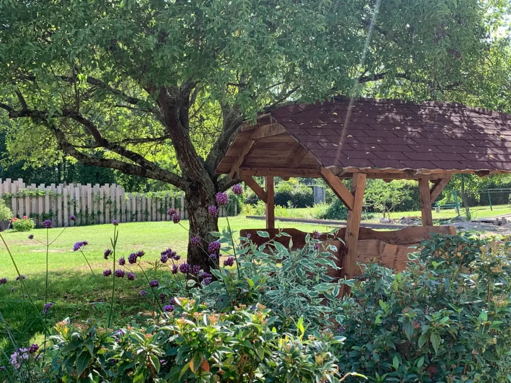 Puits en bois sous un arbre fleuri