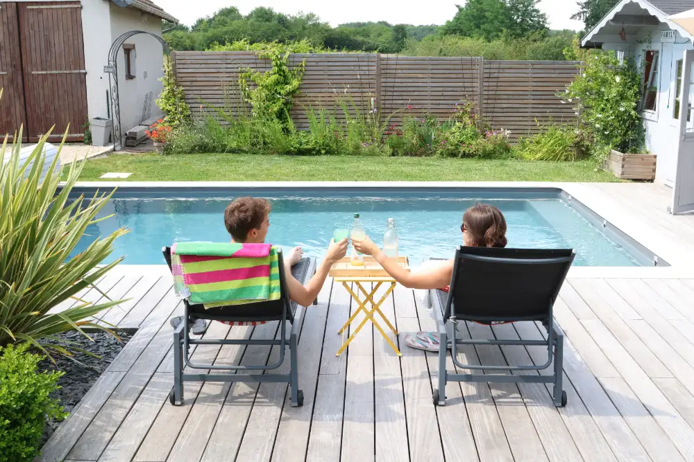 Couple assis au bord d’une piscine extérieure