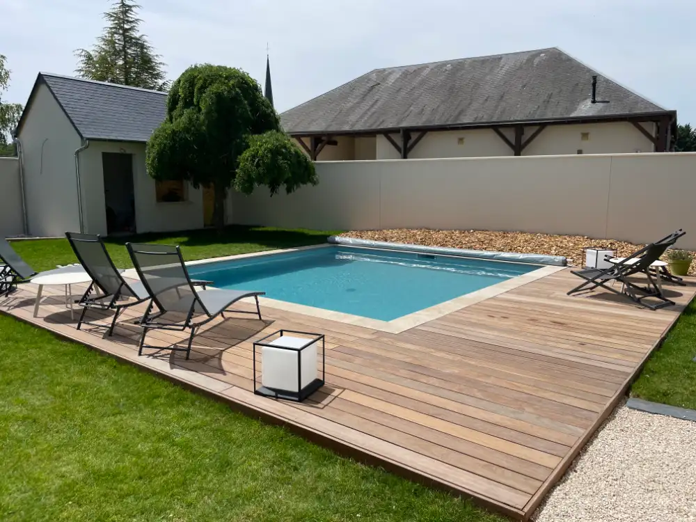 Piscine extérieure avec terrasse en bois et transats