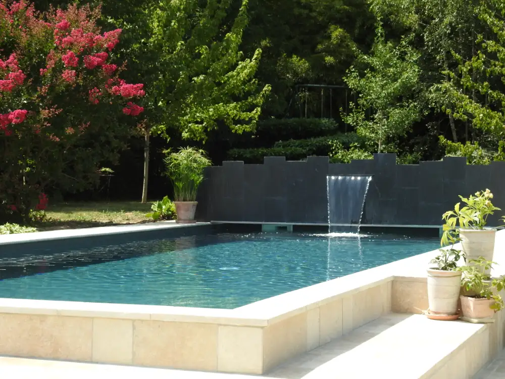 Piscine moderne avec cascade et jardin verdoyant