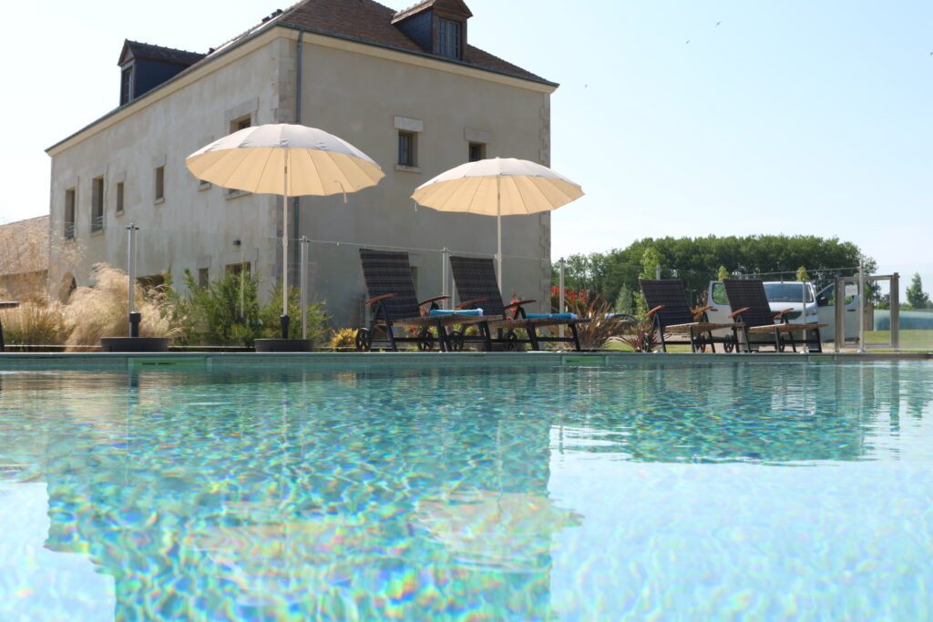 Piscine extérieure avec transats et parasols blancs