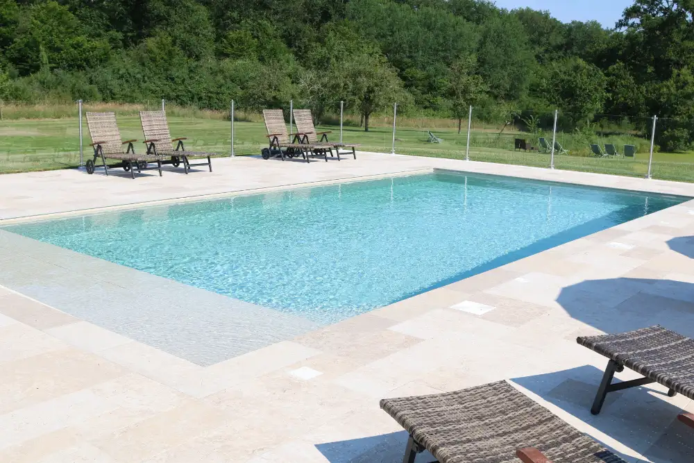 Piscine extérieure avec transats et jardin verdoyant