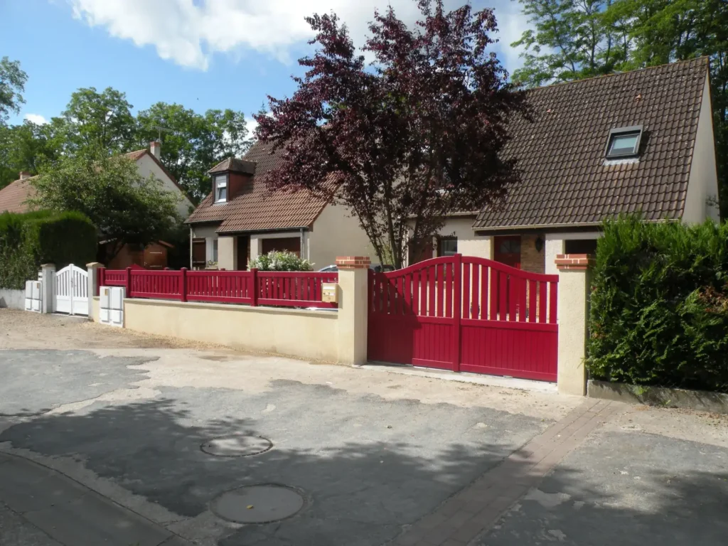 Maison avec portail rouge et jardin arboré