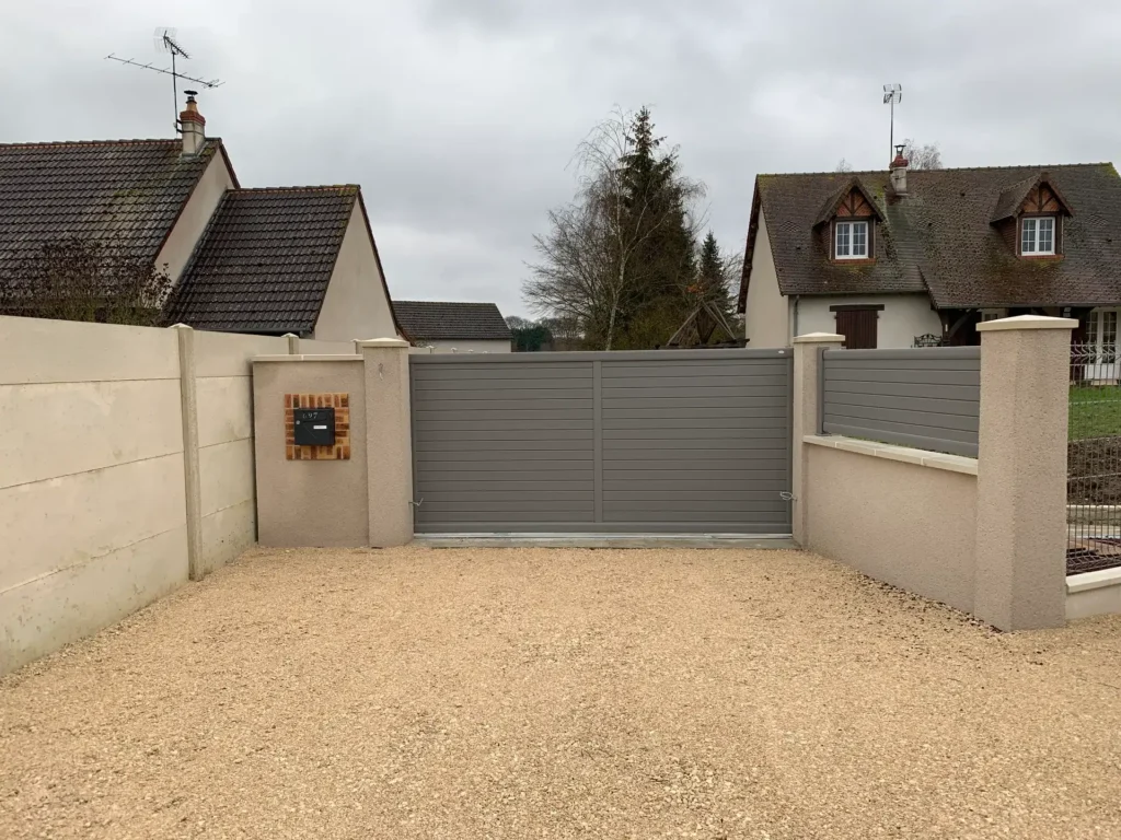 Portail coulissant gris devant maison pavillonnaire