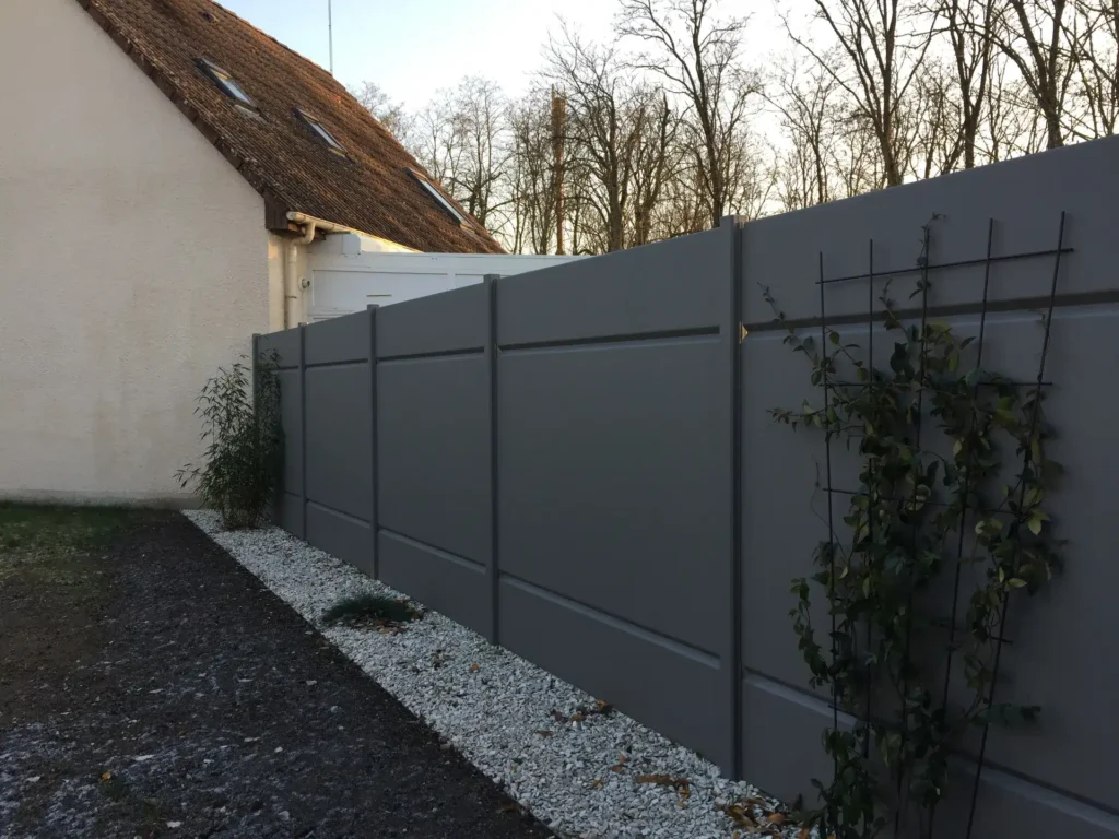 Clôture moderne grise le long d’une maison