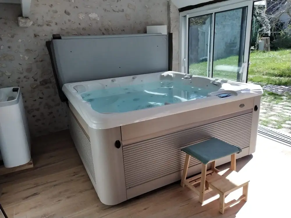 Spa jacuzzi intérieur près baie vitrée jardin