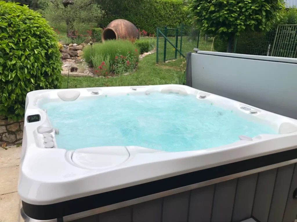 Spa extérieur bouillonnant dans jardin verdoyant