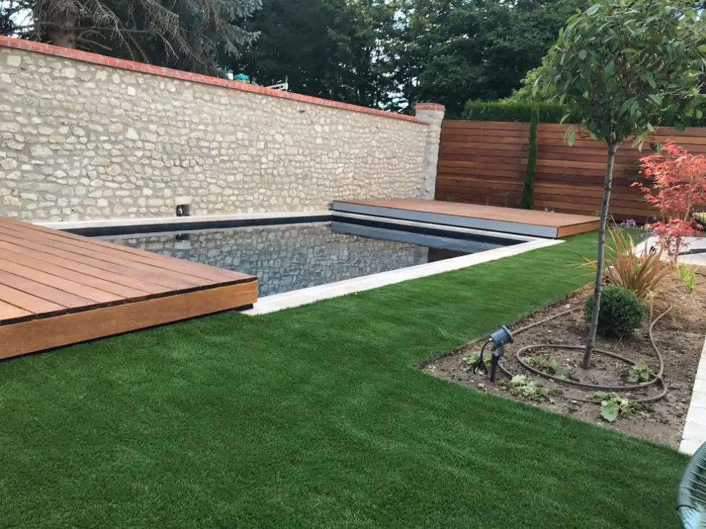 Piscine moderne avec terrasse bois et jardin paysager