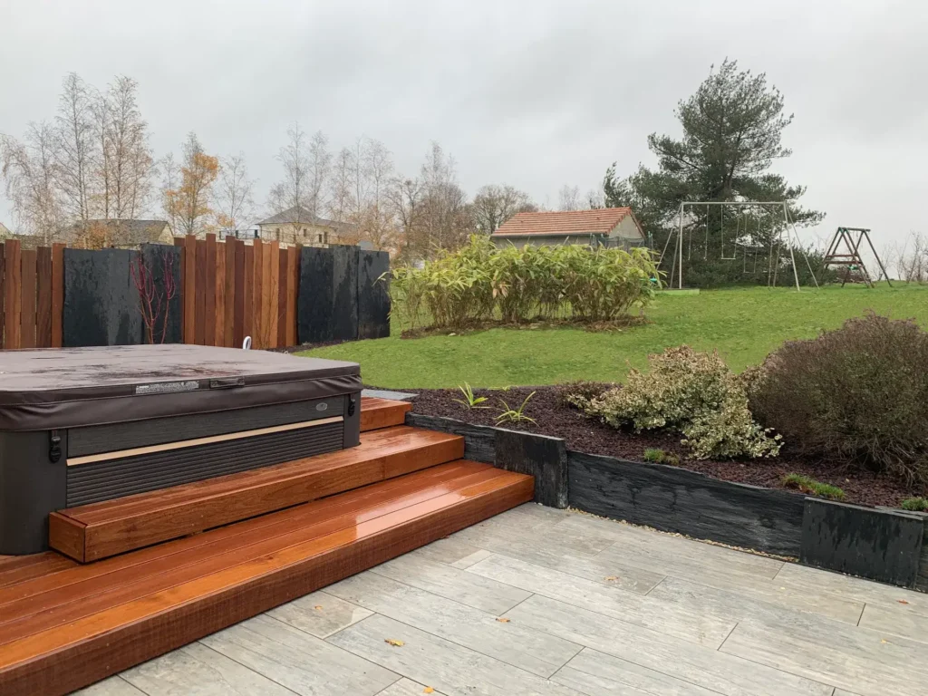 Jardin avec terrasse en bois et jacuzzi extérieur