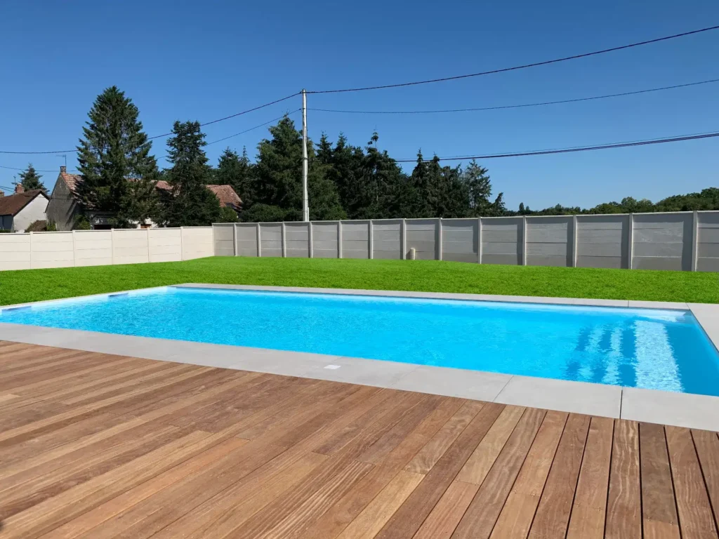 Piscine moderne avec terrasse en bois et jardin