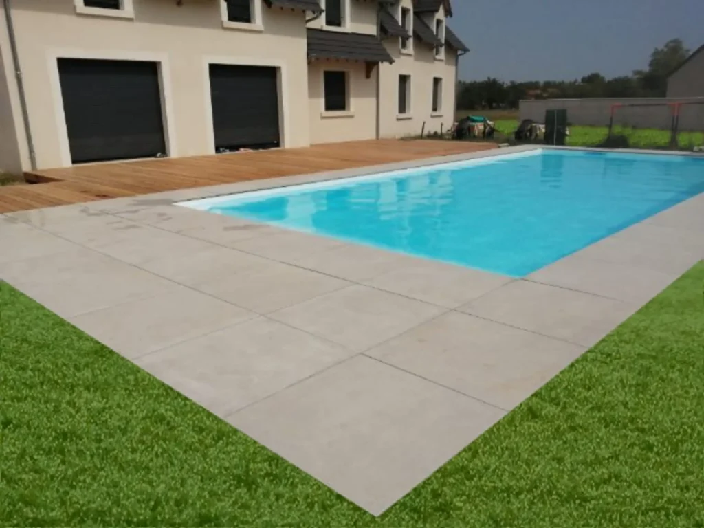 Piscine moderne devant maison avec terrasse en bois