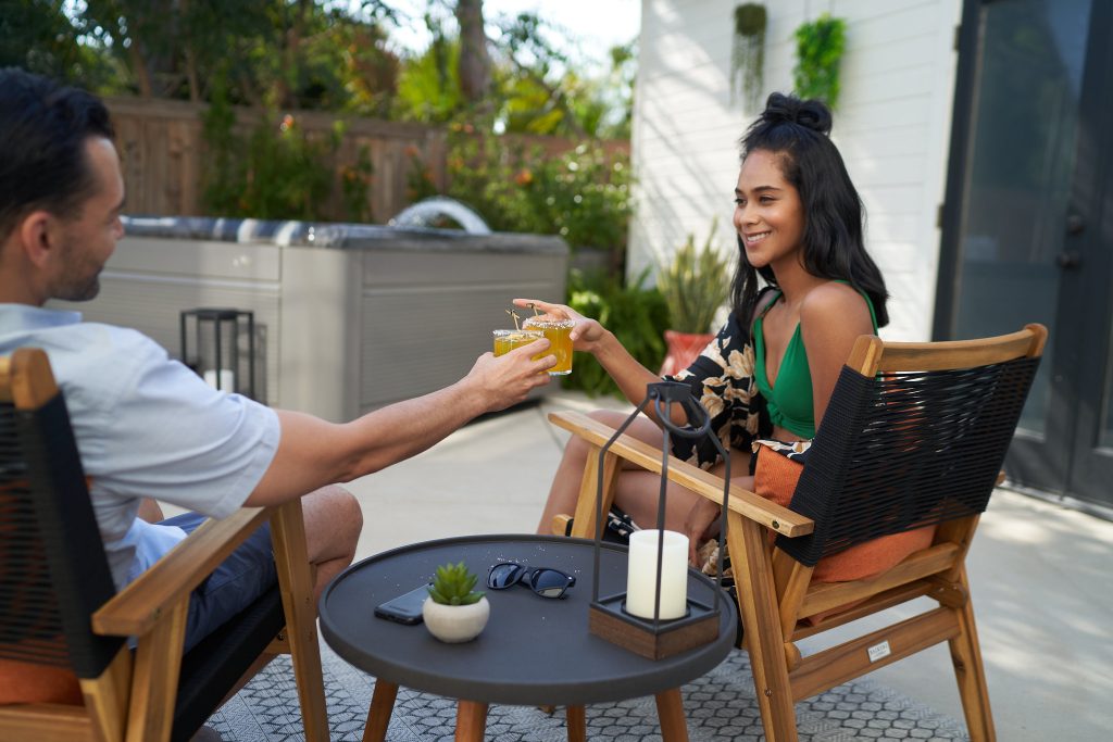 Couple trinquant avec cocktails sur terrasse ensoleillée