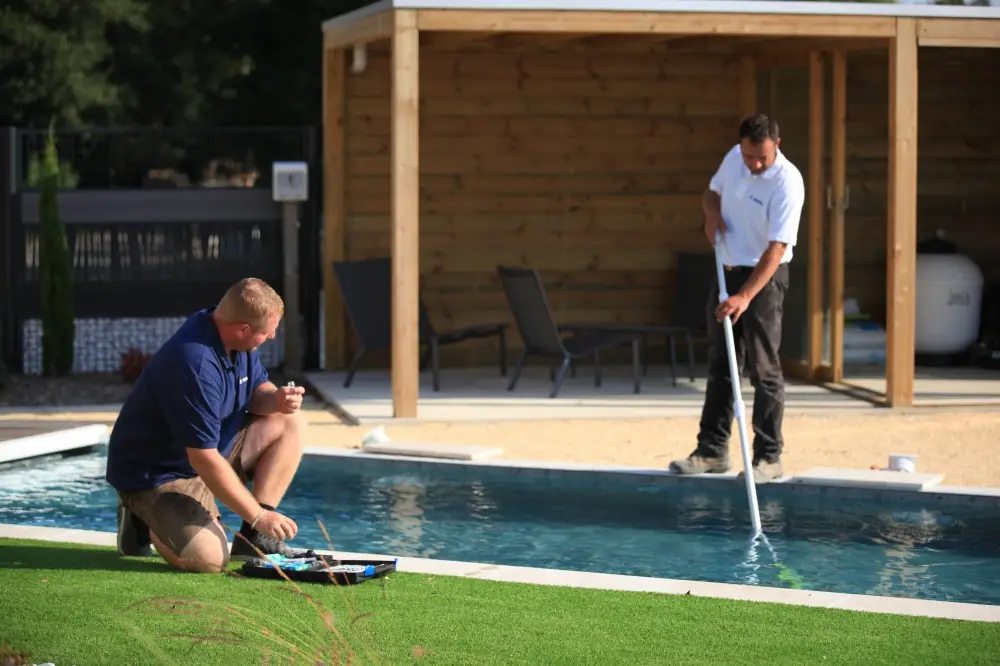 Deux hommes entretiennent une piscine extérieure